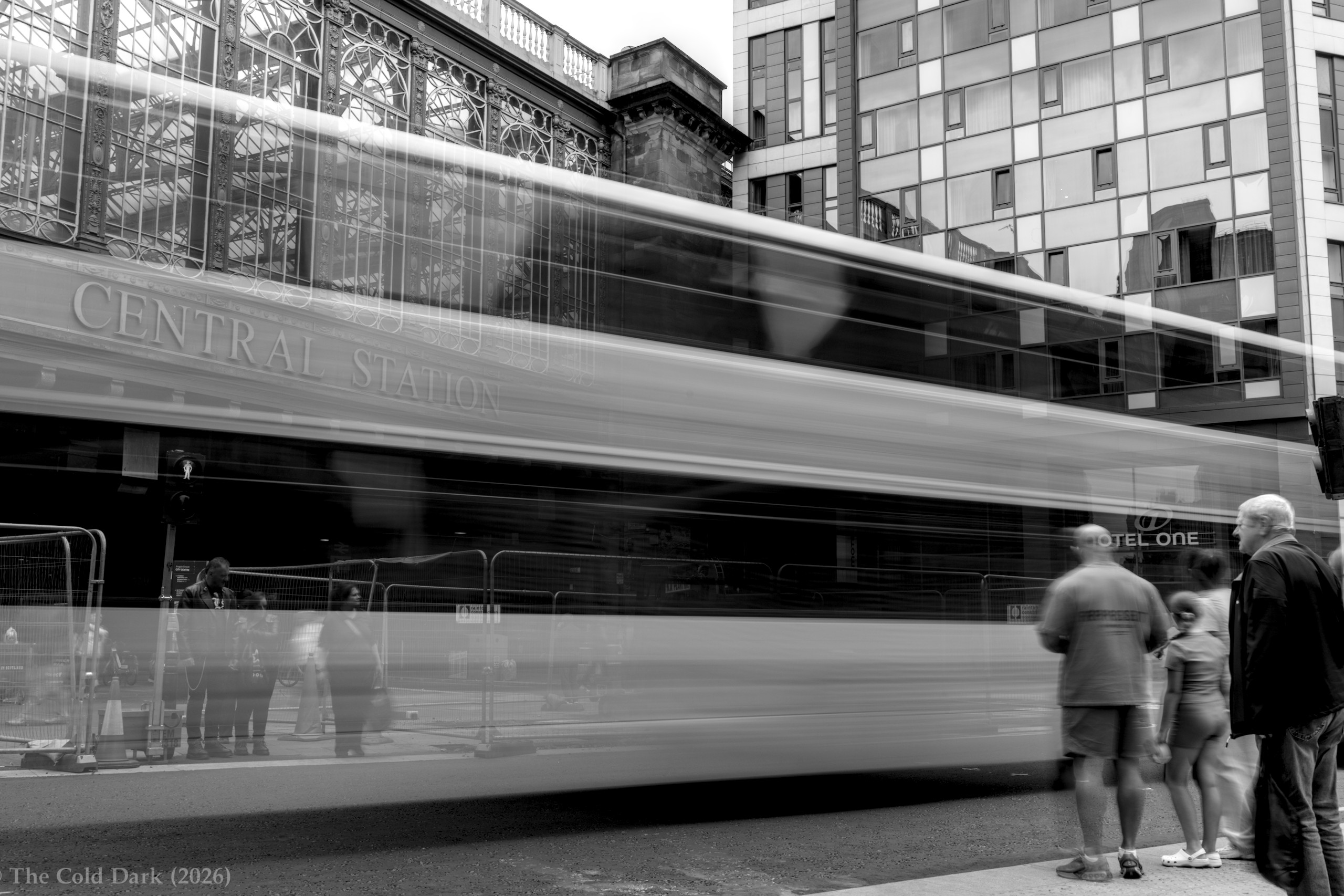 A city bus blurs past Glasgow Central Station.